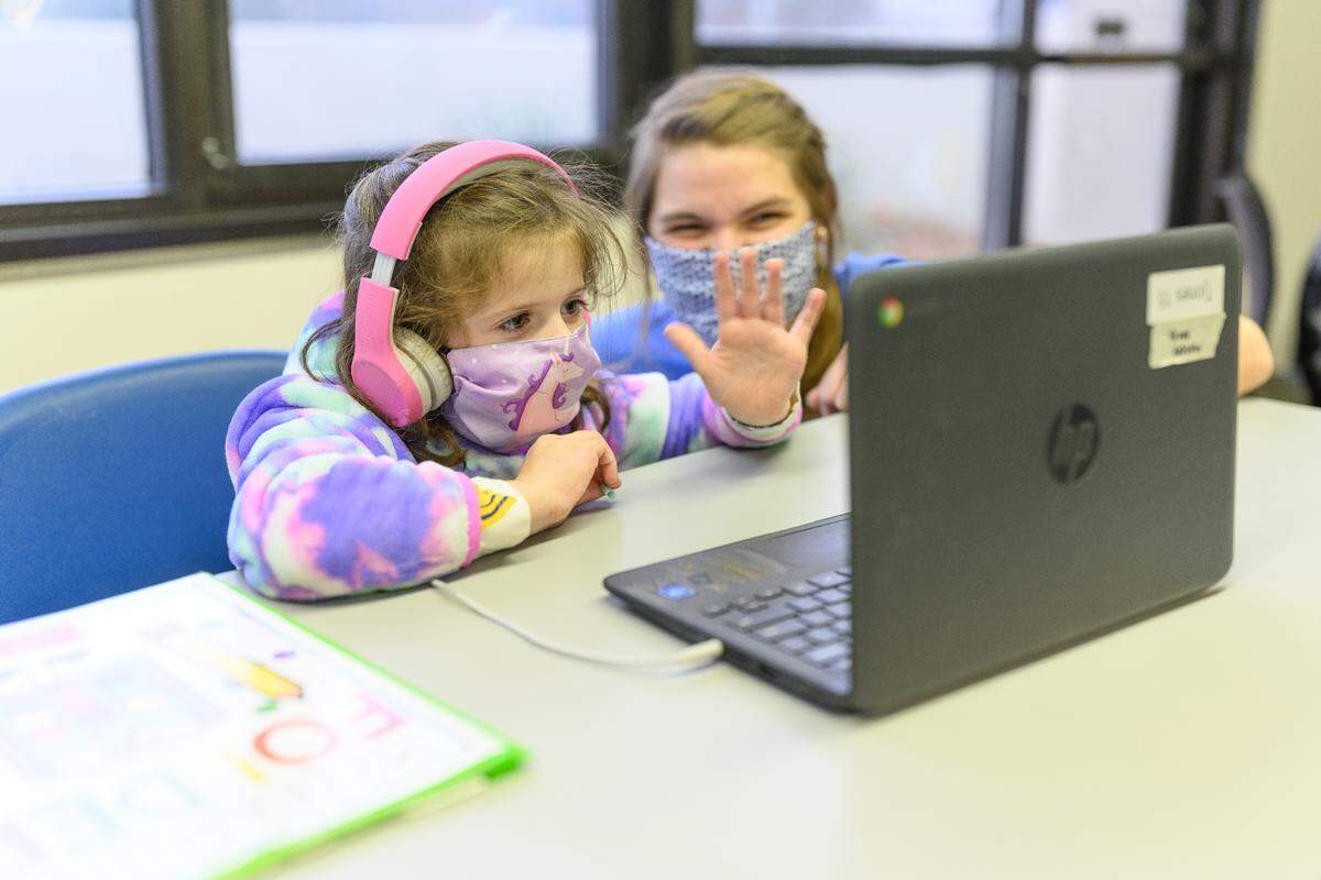 A child at the University of Kentucky’s Y Academy waves during a video call in December.