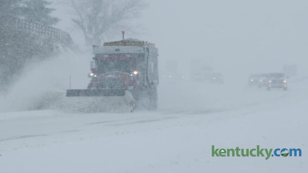 A snow plow led traffic along Versailles Road.