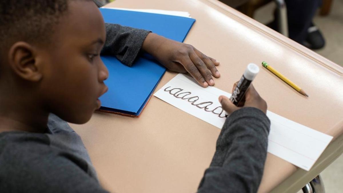 In this Wednesday, March 1, 2017, photo, a third-grader practices his cursive handwriting at P.S.166 in the Queens borough of New York.