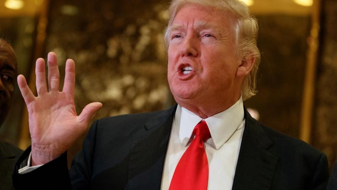 President-elect Donald Trump speaks with reporters Friday in the lobby of Trump Tower in New York.