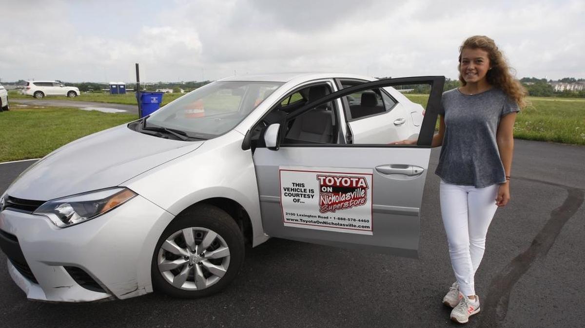 Kate Christensen, the 1,000th student in a defensive driving school for young drivers, stood with a practice car Friday at the Fayette County Attorney Drivers Education practice pad.