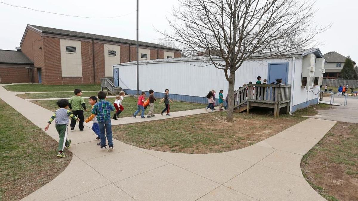 Students walked into a portable classroom behind Rosa Parks Elementary in Lexington last week. The school is expected to get another portable unit in the fall.