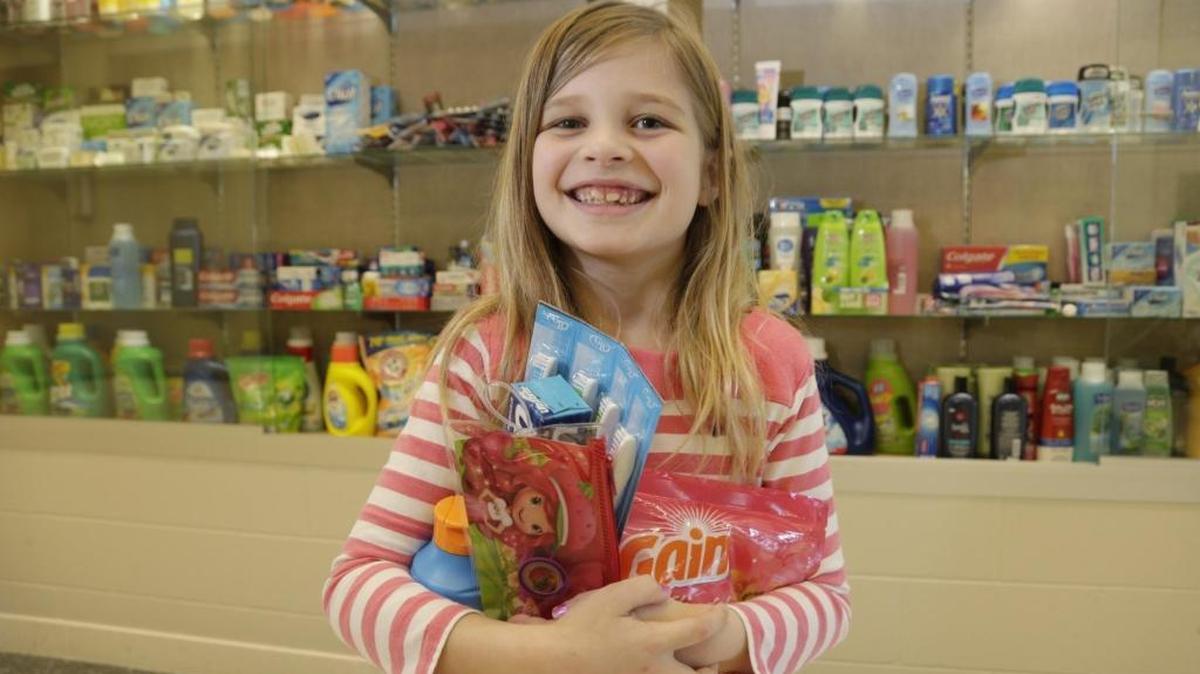 Seven-year-old Anneliese Morgan with items collected by Glendover Elementary students for refugees. Morgan started a service project at Glendover, and collected dozens of toiletry items for Kentucky Refugee Ministries.