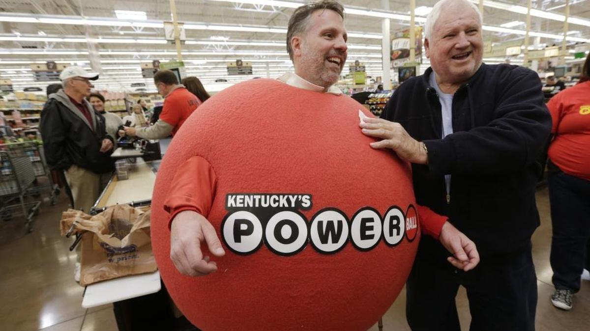 Kenneth Burton rubbed his free ticket on Kentucky Lottery Vice President Pete Ramsey's costume for luck during a Powerball ticket giveaway at the Brannon Crossing Kroger in Nicholasville, Ky., on Jan. 13, 2016.