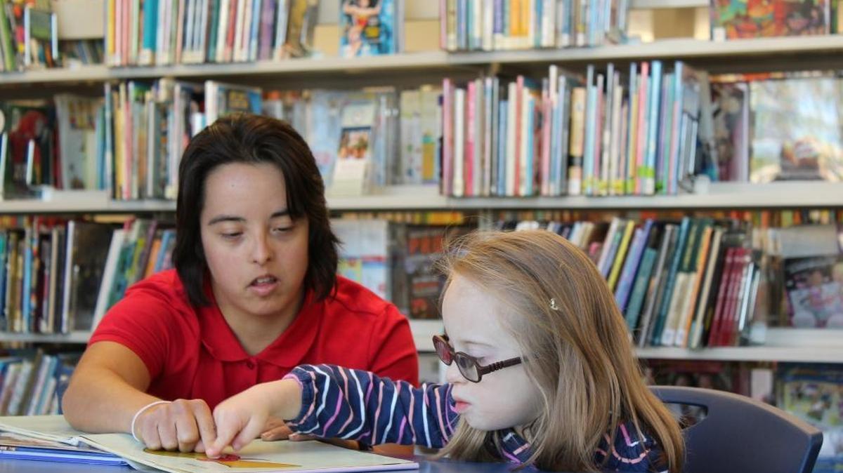 In addition to working at Millcreek Elementary, Megan McCormick works Saturdays for the Learning Program at the Down Syndrome Association of Central Kentucky. Here she’s tutoring Dailey Hall, one of the students from the program, in reading at the association’s library.