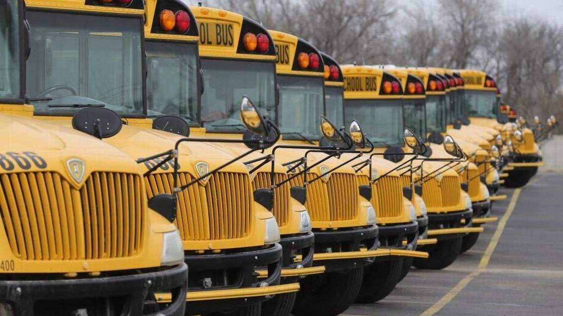 Buses parked at a storage lot.