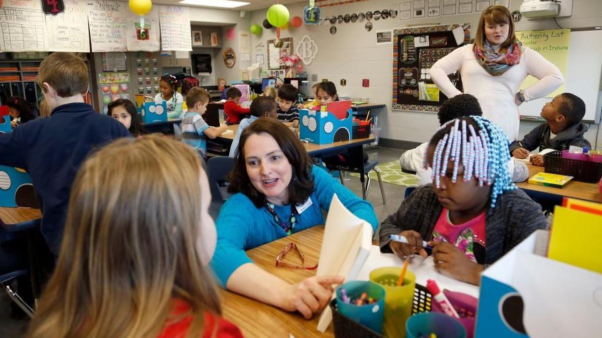 Fayette County Public Schools writing coach Michelle Tudor worked with Chloe Albertson, left, and Cheyane Frye, right, as classroom teacher Ellen Bradley worked with students in the background at Deep Springs Elementary School. Tudor, a professional growth and effectiveness system coach who helps teachers, was teaching a writing lesson to students in Bradley’s second-grade class. It’s part of Superintendent Manny Caulk’s partnership zone initiative, which is trying to lift up achievement at all the elementary and middle schools that feed into Bryan Station High School.