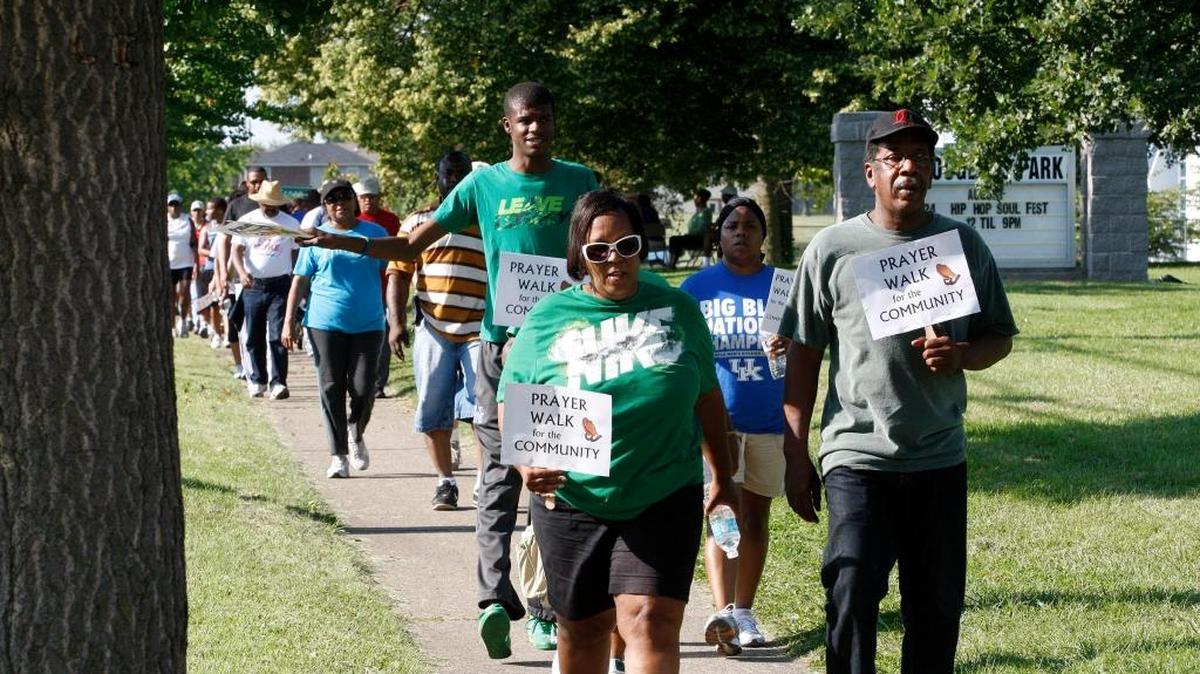 Sherry and Terry Brown held signs as they marched in the Prayer Walk near Douglass Park on Georgetown Street in Lexington on Aug. 25, 2013.