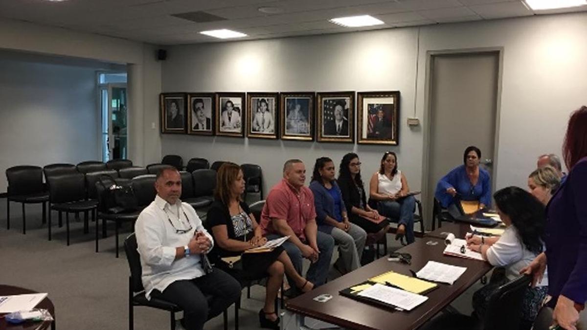 Fayette County Public Schools staff (sitting at the table) interview bilingual job candidates in Puerto Rico (sitting in row of chairs) for Fayette teaching positions.