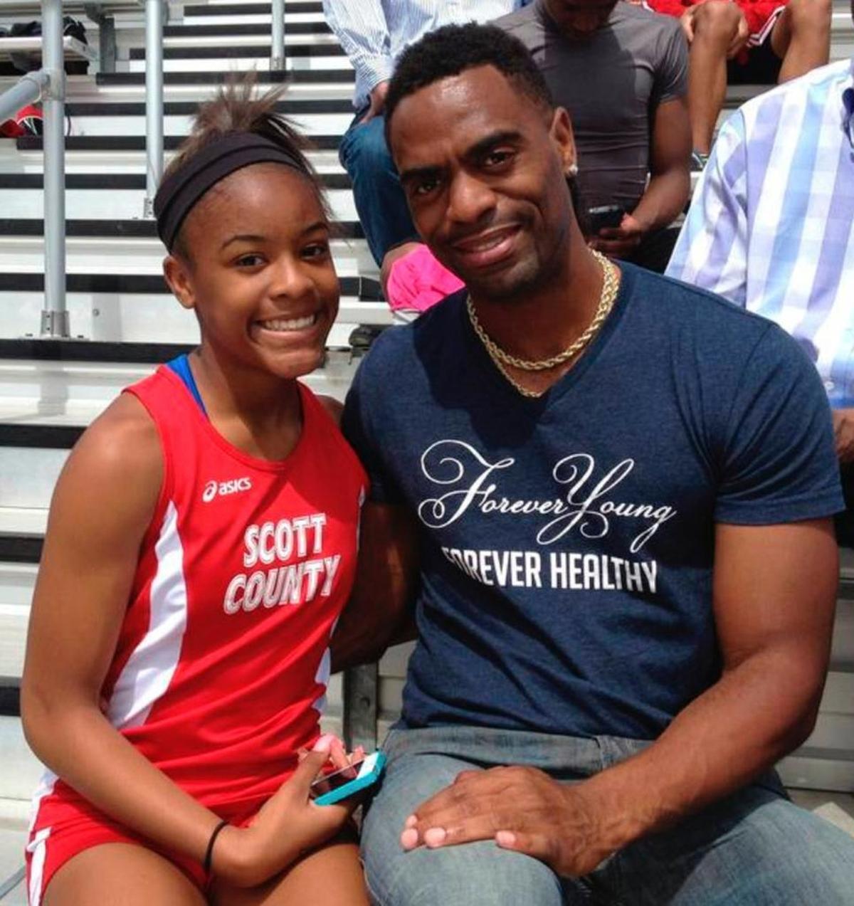 In this May 3, 2014, file photo, Trinity Gay, a seventh-grader racing for her Scott County High School team, posed for a photo with her father, sprinter Tyson Gay, after she won the 100 meters and was part of the winning 4-by-100 and 4-by-200 relays at the meet in Georgetown, Ky.
