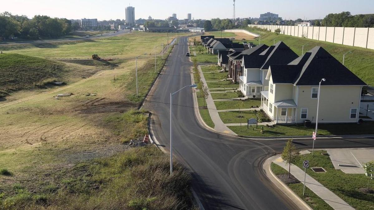 Towers on the University of Kentucky campus are visible at the end of the Oliver Lewis Way corridor as seen from the Versailles Road bridge. Oliver Lewis Way, which connects Newtown Pike to South Broadway, is at the far left. At right are the beginnings of an affordable housing development to replace Davis Bottom, which before it was cleared in 2011 had been home to some of Lexington’s poorest residents since the Civil War.