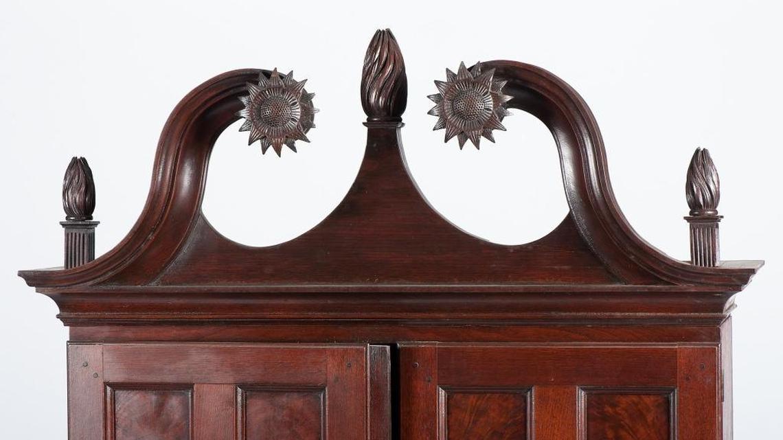 This detail shows the broken-arch pediment with carved sunflower rosettes, topped by three well-carved flame finials, at the top of the Chippendale desk and bookcase that was commissioned by Captain John Cowan in 1796 near present-day Danville. The desk remained in his family for 200 years and is the only Kentucky-made case piece of its kind that has yet been identified. It is up for auction in October by Cowan’s Auctions, based in Cincinnati.