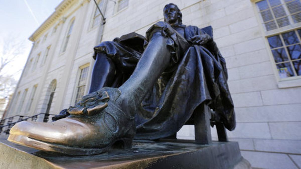 In this March 13, 2016 file photo, a sculpture in bronze of John Harvard rested on the campus of Harvard University, in Cambridge, Mass.