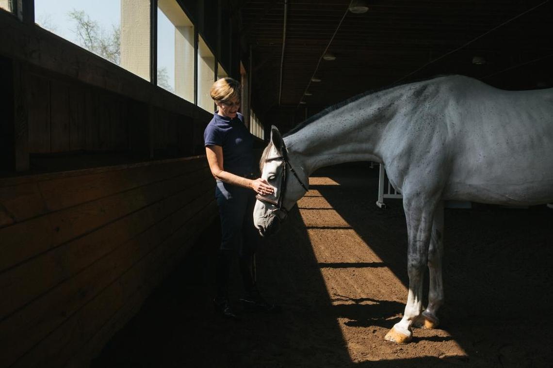 Anne Kursinski, a two-time Olympic medalist equestrian, pets Carpion, one of the horses on her farm in Frenchtown, N.J. Kursinski and four other women have opened up about the childhood sexual abuse they suffered at the hands of the celebrated equestrian trainer Jimmy A. Williams, who died in 1993. “I was a little kid. And he was God,” Kursinski said.