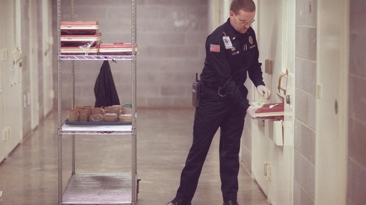 Lt. Fred Wilson collects food trays from inmates at the East Kentucky Correctional Complex in West Liberty, Ky., on Jan. 21, 1999.