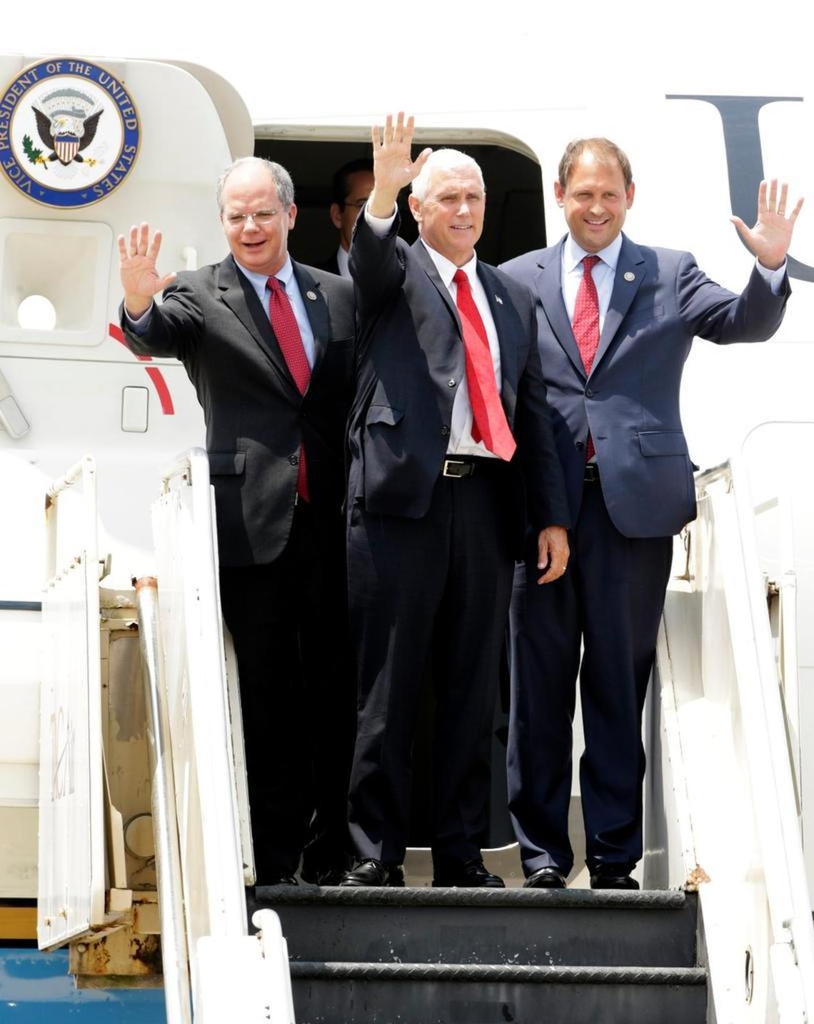Vice President Mike Pence, center, accompanied by U.S. Reps. Brett Guthrie, left, and Andy Barr, wave to press and supporters from Air Force Two after their arrival at Blue Grass Airport in Lexington, Ky, on July 12, 2017.
