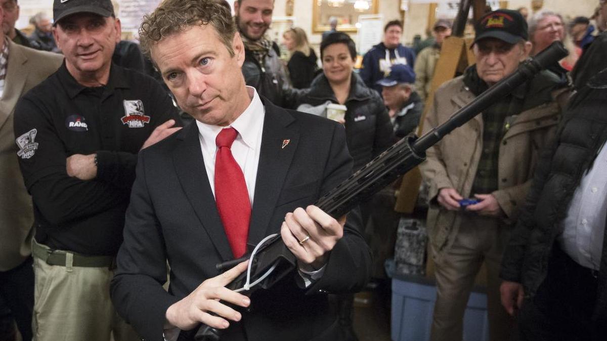 Republican presidential candidate, Sen. Rand Paul, R-Ky., handles a AR-15 style rifle as he meets with customers during a campaign stop at a gun show at Bektash Shrine Center, Saturday, Jan. 23, in Concord.