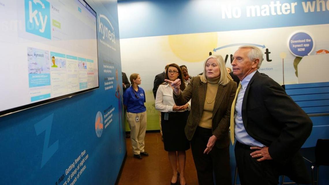 Governor Steve Beshear , right listened as Carrie Banahan, Executive Director of the Kentucky Health Benefits Exchange, center, and Nicole Comeaux , left, told him about the new Kynect app as the State opened a storefront at the Fayette Mall where people could sign up for health insurance on Thursday November 13, 2014 in Lexington, Ky.