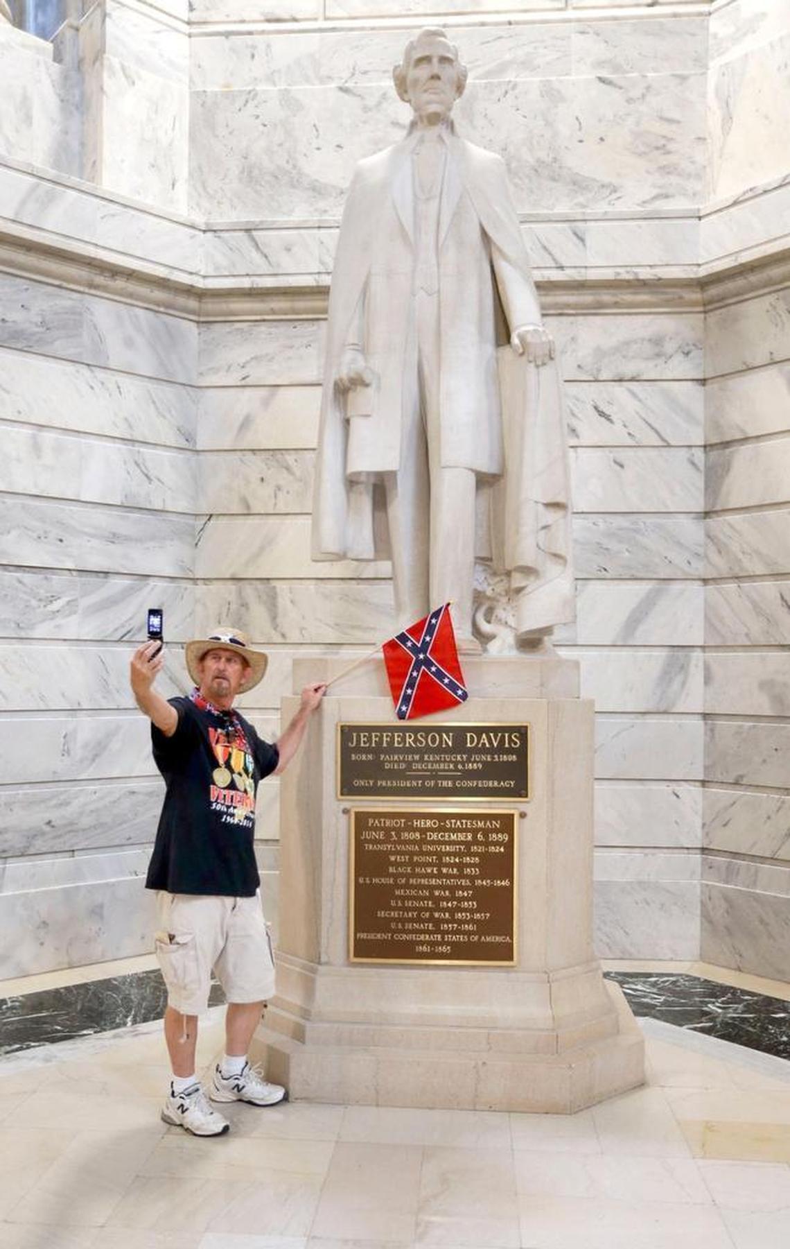James Hendrickson, Corbin, took a "selfie" with the Jefferson Davis Statue following a rally in support of keeping the statue of Confederate president Jefferson Davis in the Capitol, held on the steps of the State Capitol in Frankfort, Ky., Friday, July 24, 2015. The Kentucky chapter of the Sons of Confederate Veterans organized the rally. After the photo, he attached the flag to the statue.