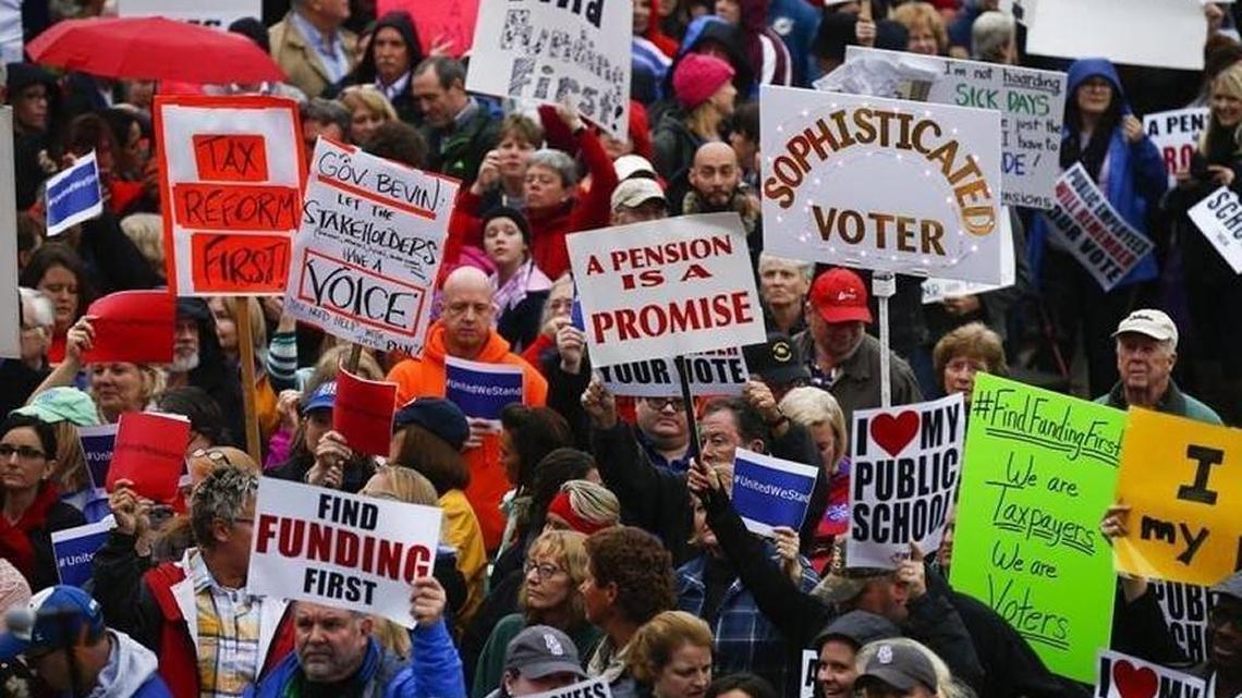 Demonstrators held signs during a Nov. 1 rally at the Capitol against the Republican proposal to reform the state’s pension system.