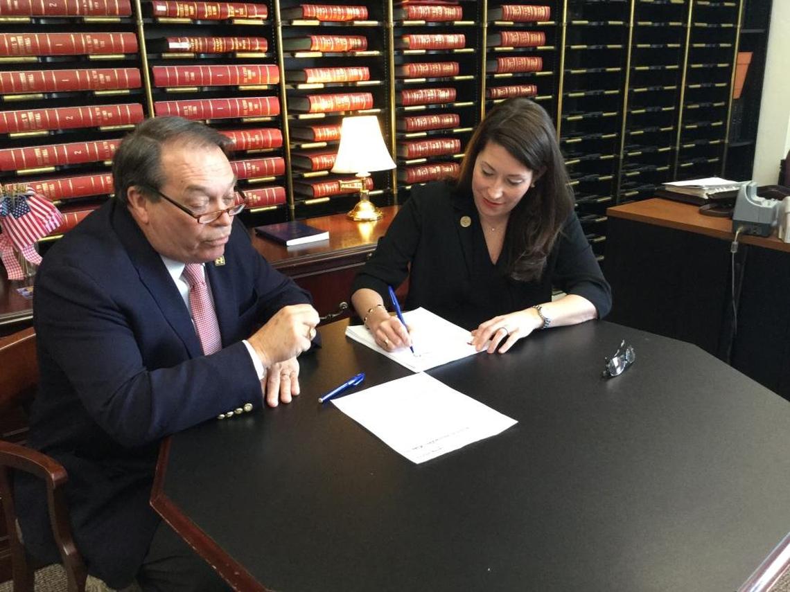 Kentucky Secretary of State Alison Lundergan Grimes signs the filing papers of Democratic presidential hopeful Hillary Clinton. They were brought to her office by Clinton representative Jerry Lundergan.