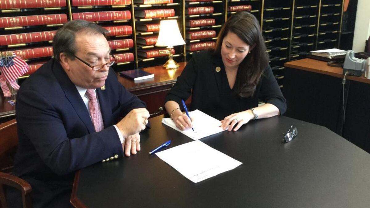 Kentucky Secretary of State Alison Lundergan Grimes signs the filing papers of Democratic presidential hopeful Hillary Clinton. They were brought to her office by Clinton representative Jerry Lundergan.