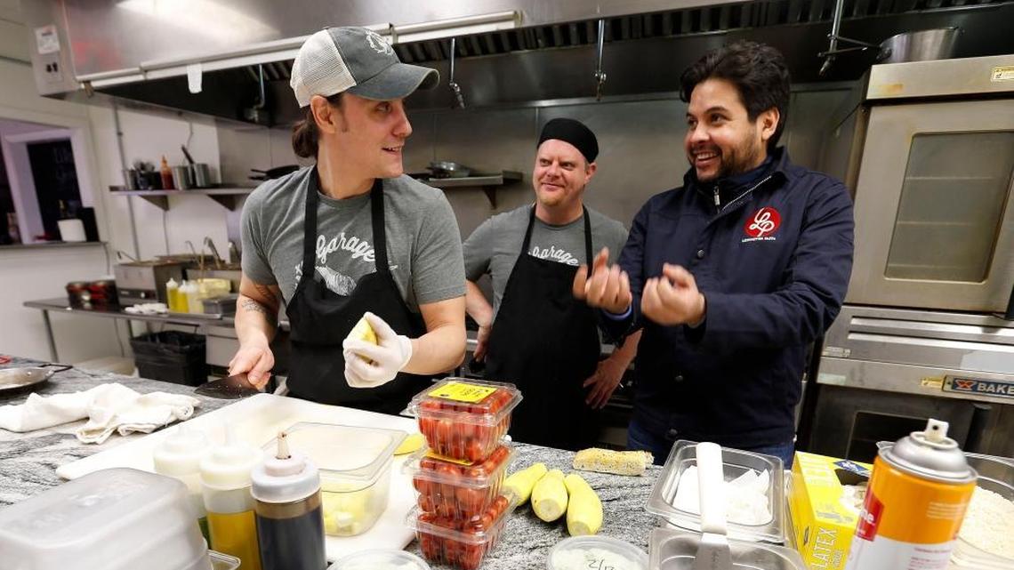 Lesme Romero, right, joked with chefs Jordan Noel, left, and Paul Nowacki, middle, in his Lexington Pasta Garage Italian Cafe.