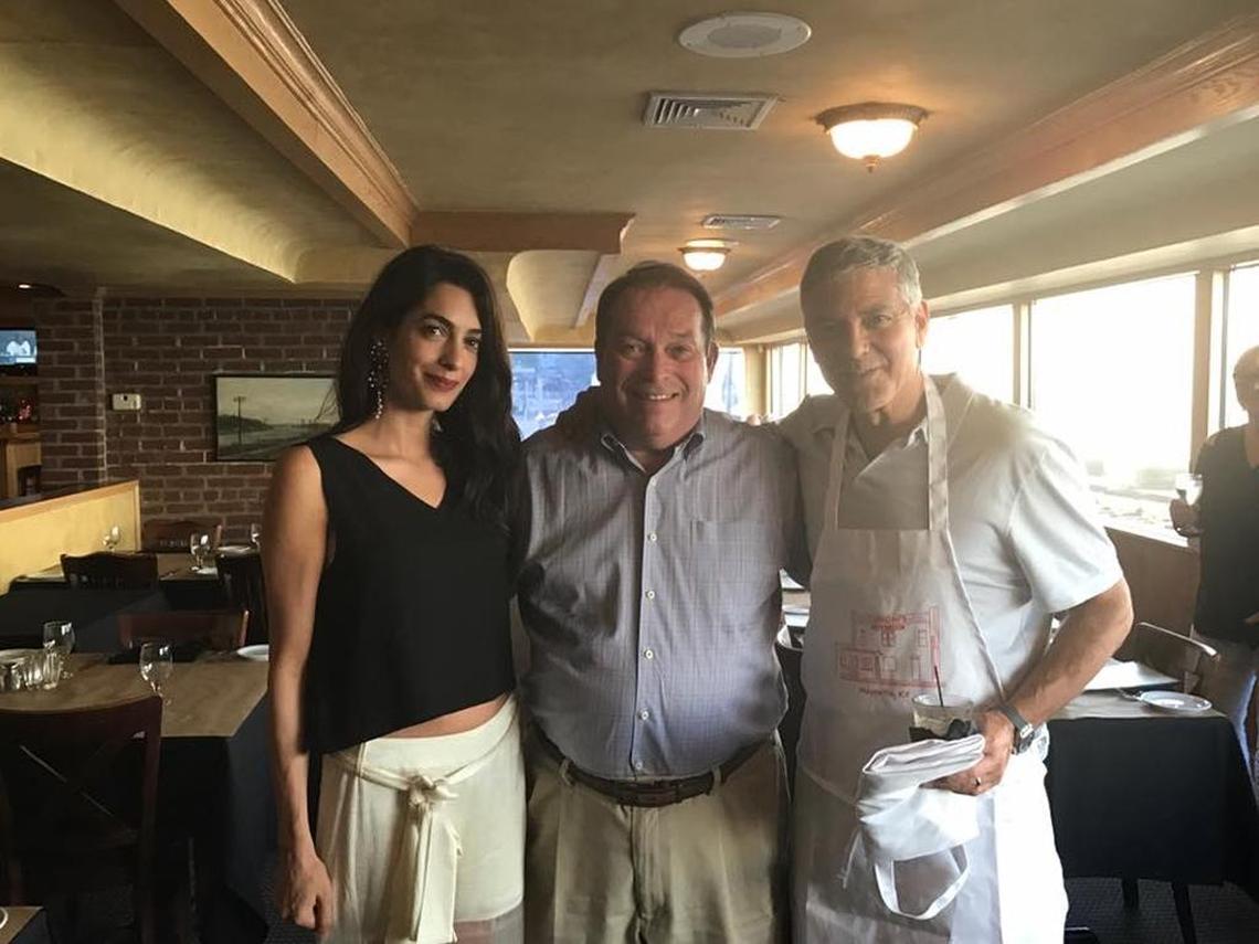 George Clooney, right, donned an apron from Caproni’s on the River restaurant in Maysville the evening of Monday, Sept. 4, 2017, as his wife, Amal, and he took a photo with restaurant owner Jerry Lundergan of Lexington.