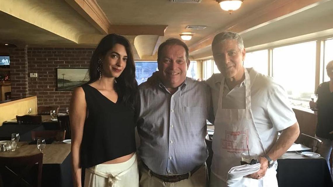 George Clooney, right, donned an apron from Caproni’s on the River restaurant in Maysville the evening of Monday, Sept. 4, 2017, as his wife, Amal, and he took a photo with restaurant owner Jerry Lundergan of Lexington.