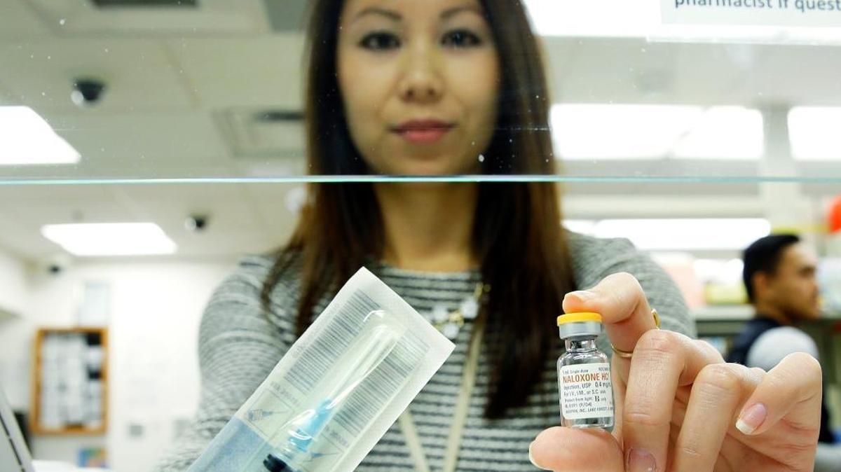 Tess Nishida, a pain pharmacist at the University of Washington, poses for a photo Friday, Oct. 7, 2016, holding a vial of Naloxone, which can be used to block the potentially fatal effects of an opioid overdose.