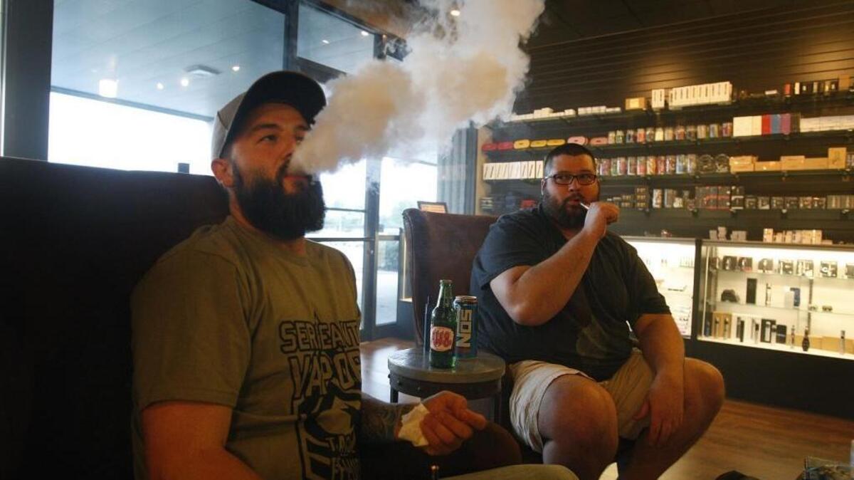 Johnathon Gray, left, chucks vapor as Joshua Fields vapes at 723 Vapor on Richmond Rd. in Lexington, Ky., Saturday, August 28, 2014.