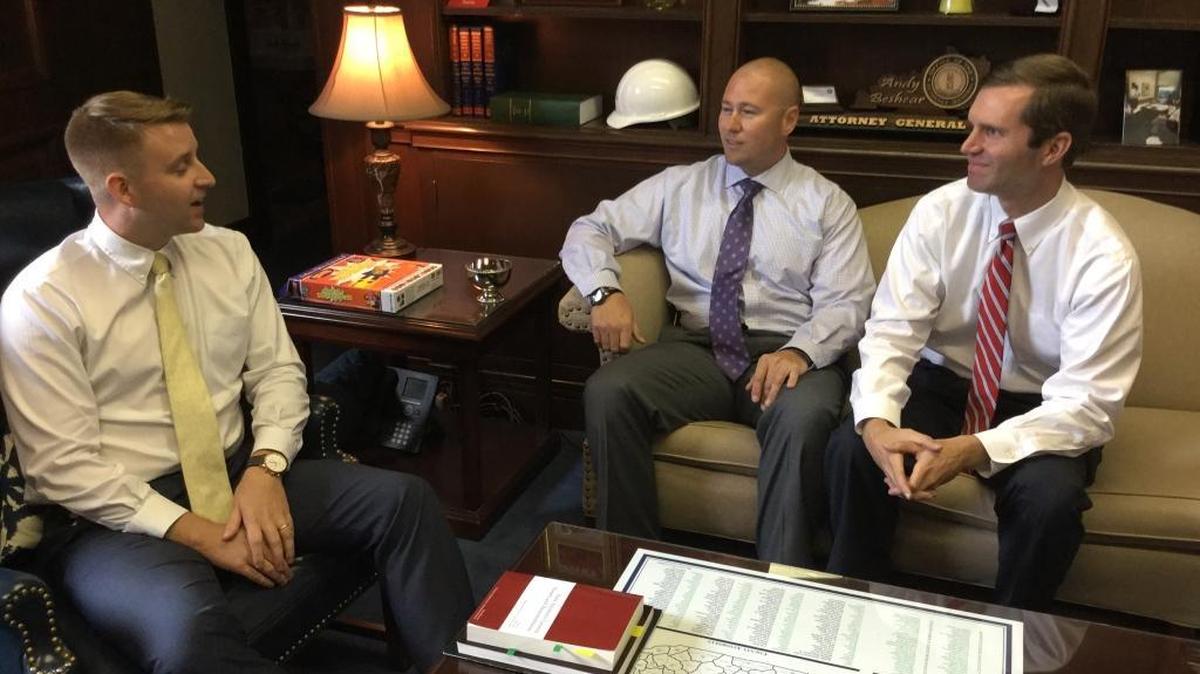 Attorney General Andy Beshear, right, talks to director of office initiatives Jonathan Smith, far left, and investigator Josh Keats about the assistance they provided Sept. 7, 2017, to an overdosed man in downtown Lexington traffic.