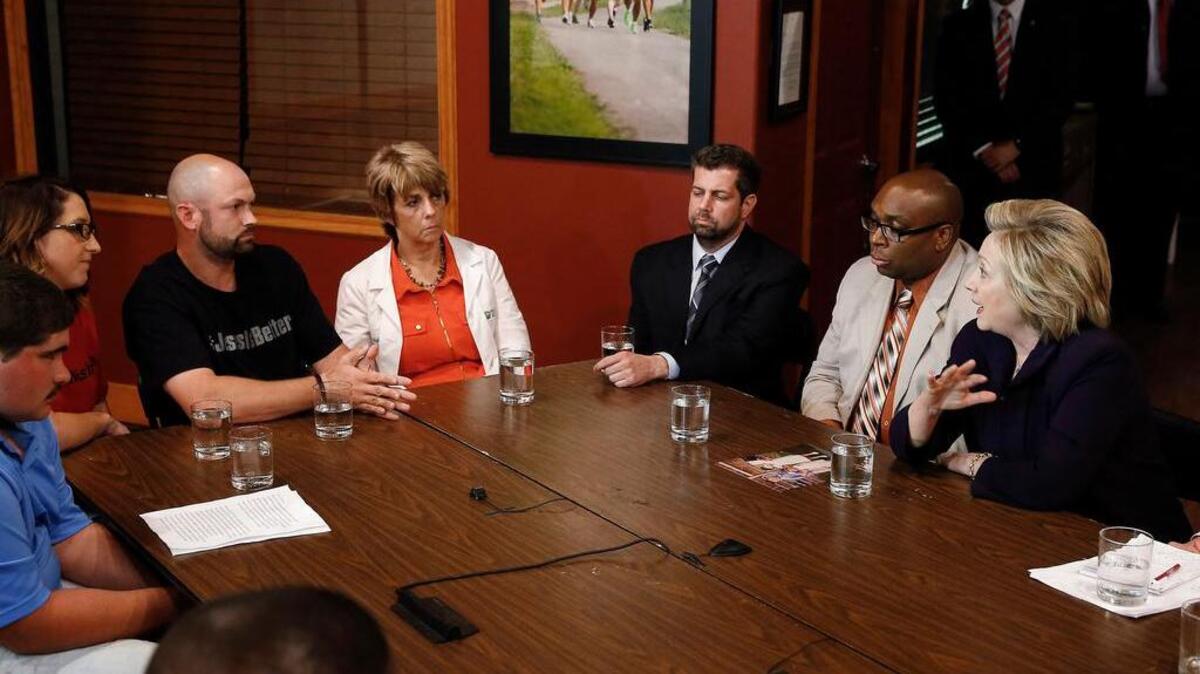 Bo Copley, fifth from right, talks with Democratic presidential candidate Hillary Clinton, right, during a round table discussion at Williamson Health and Wellness Center in Williamson, W.Va., Monday, May 2, 2016. (AP Photo/Paul Sancya)