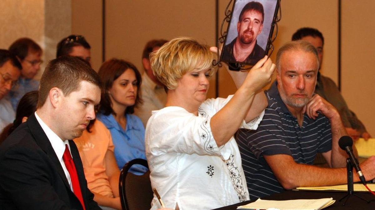 Melissa Lee, widow of Jimmy D. Lee, showed a photo of her husband who died in the Darby explosion in Harlan County in 2006, during testimony of a Mine Safety and Health Administration public hearing concerning mine seals in Lexington, Ky., on Thursday, July 12, 2007. Widows of miner are pursuing better inspection and enforcement of mine seal regulations as well as some tougher rules. Lee was flanked by her lawyers, Wes Addison, left and Tony Oppegard, right.