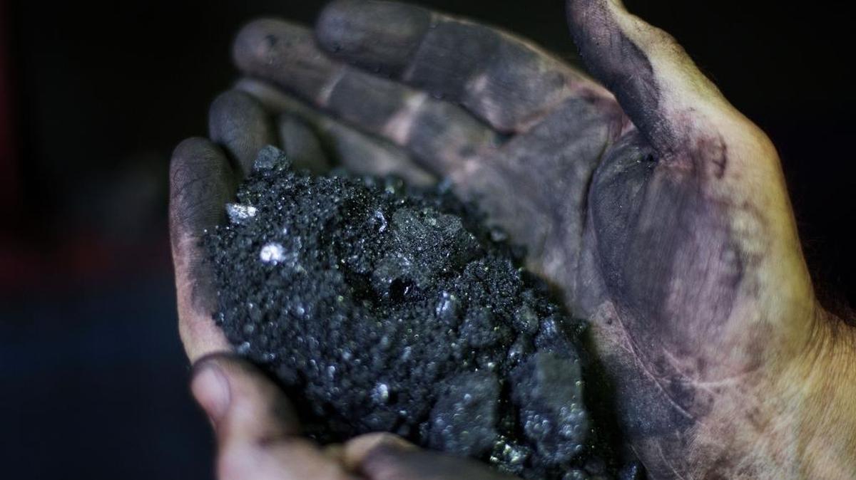 Superintendent Jackie Ratliff, a coal miner of 25 years, holds coal running through a processing plant Tuesday, Oct. 6, 2015, in Welch, W.Va. The Kentucky Public Service Commission granted Kentucky Power’s request to continue investing in the Mitchell Power Plant in West Virginia.