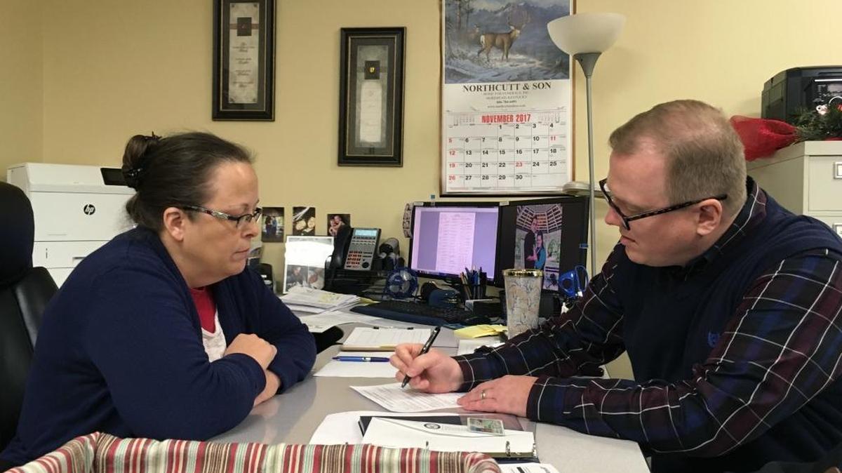 David Ermold, right, files to run for Rowan County Clerk in Kentucky as Clerk Kim Davis look on Wednesday, Dec. 6, 2017, in Morehead, Ky. Davis denied Ermold and his husband a marriage license two years ago because she was opposed to gay marriage for religious reasons.