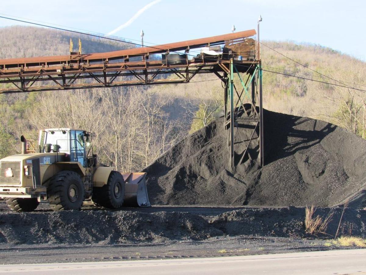 A worker uses a large front-end loader to scoop coal in Harlan County to be loaded for transport.