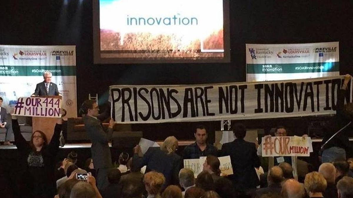 Members of the Letcher Governance Project, a citizens group based in Whitesburg that opposes construction of a federal prison in Letcher County, unfurled a banner in June 2016 during a SOAR Summit while Congressman Hal Rogers was at the podium. Rogers has gotten funding for the prison in the House budget. #our444million refers to its projected cost. Innovation was the theme of the Shaping Our Appalachian Region gathering.