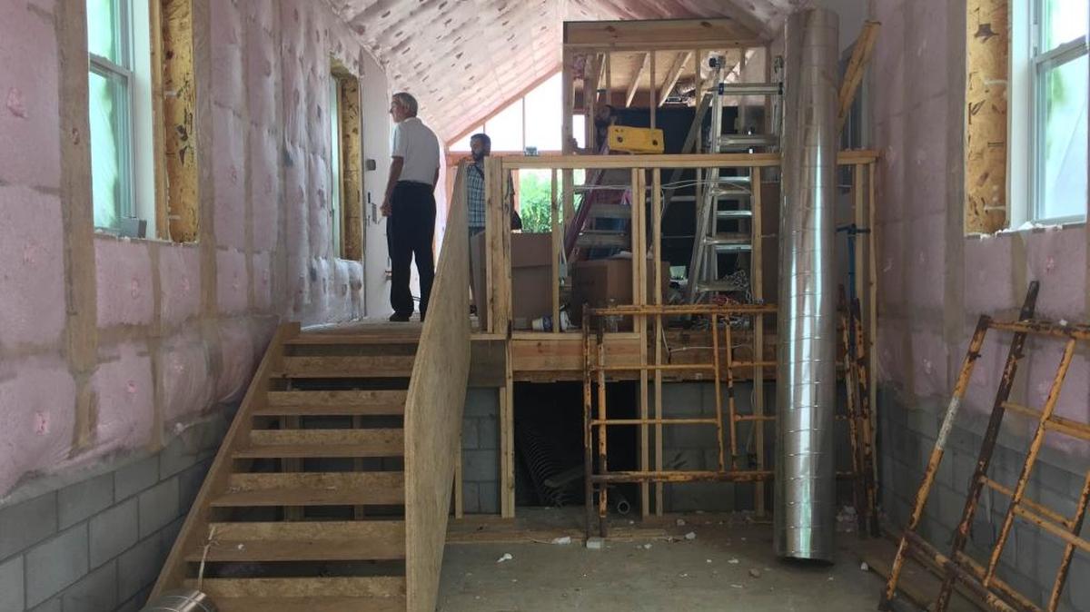Richard McQuady, right, director of Lexington’s affordable housing efforts, overlooked work inside a York Street house that will be sold. The photo is taken from the back of the house.