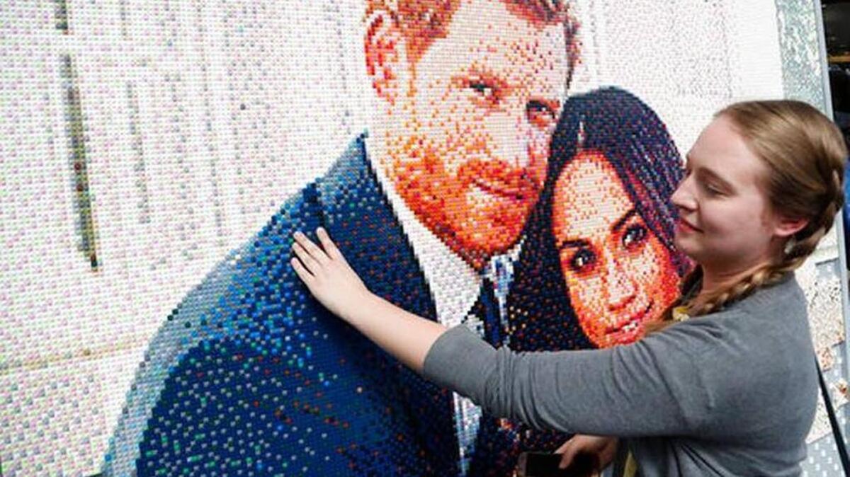 People put bricks in a mosaic of the royal couple in a shopping mall in Windsor, England, Friday, May 18, 2018. Preparations continue in Windsor ahead of the royal wedding of Britain's Prince Harry and Meghan Markle Saturday May 19.