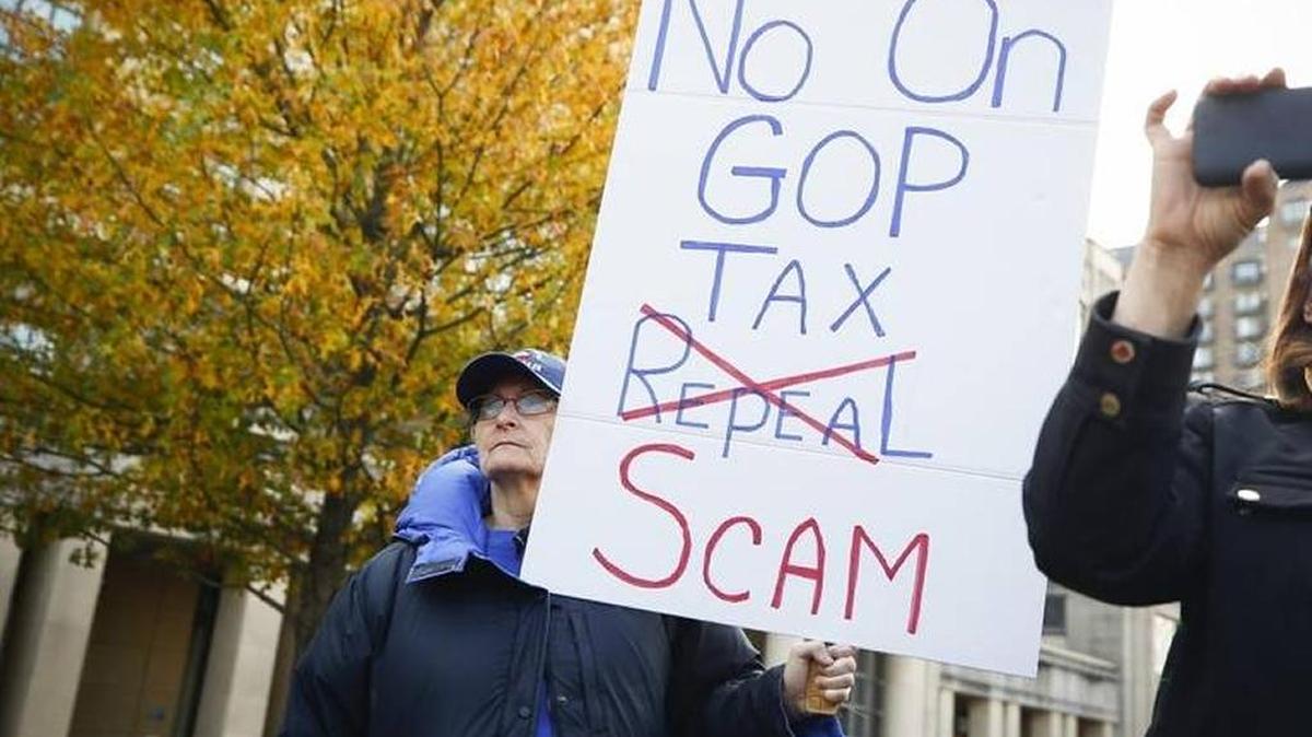 Jody Lambert of Georgetown and about 60 other people protested Republican tax plans at the Robert F. Stephens Courthouse Plaza in Lexington, Nov. 29.