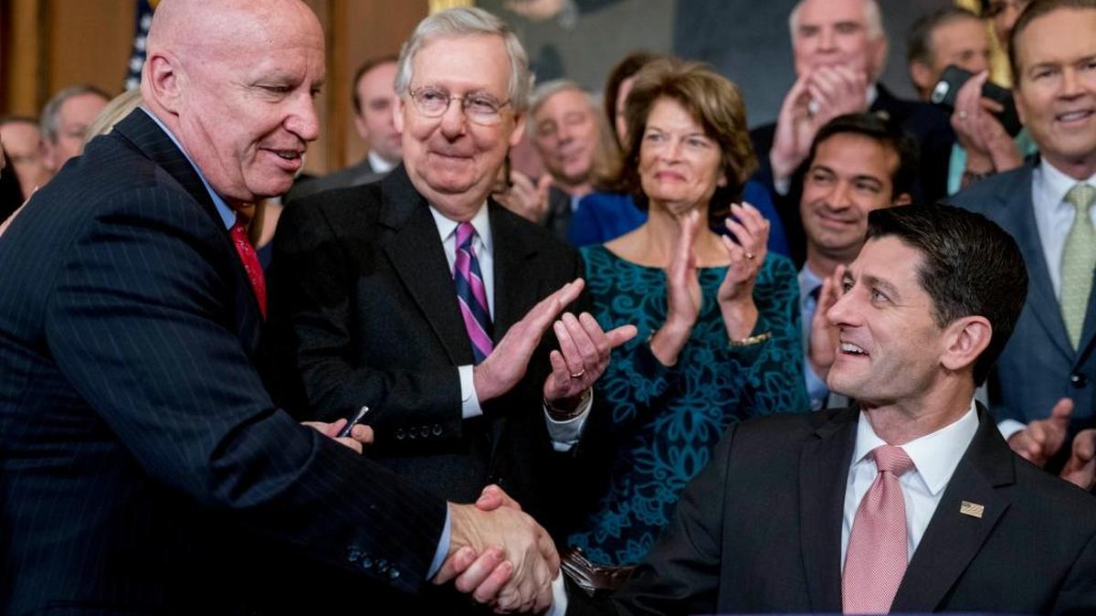 Speaker of the House Paul Ryan, shook hands after presenting a pen to House Ways and Means Committee Chairman Kevin Brady left, as Senate Majority Leader Mitch McConnell watched after signing the final version of the GOP tax bill Thursday.