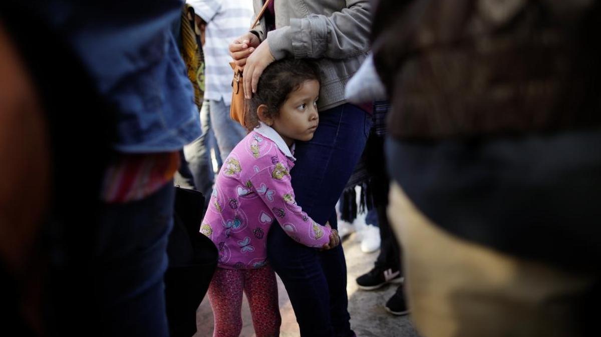 A girl held on to her mother on June 13 as they waited in Tijuana to request political asylum in the United States. More than 3,000 children have been separated from parents seeking asylum. The Trump administration missed a second deadline to reunite them.