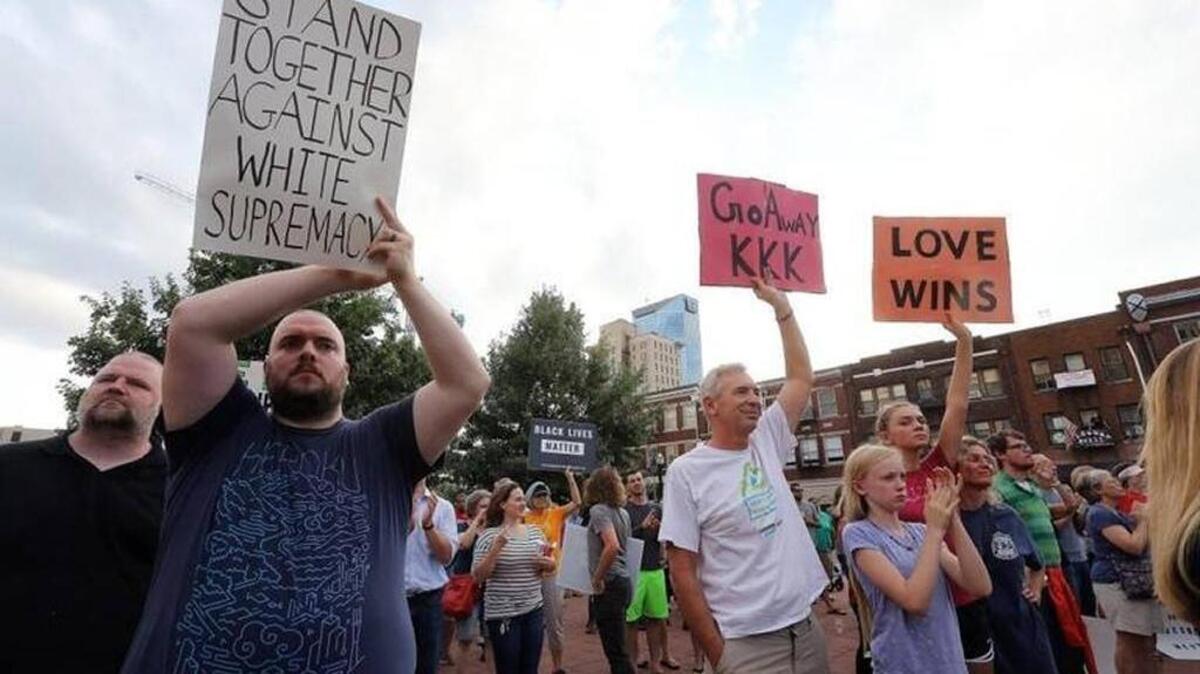 Supporters held signs at the Lexington vigil for last month’s victims of violence during a rally by white nationalists in Charlottesville, Va.