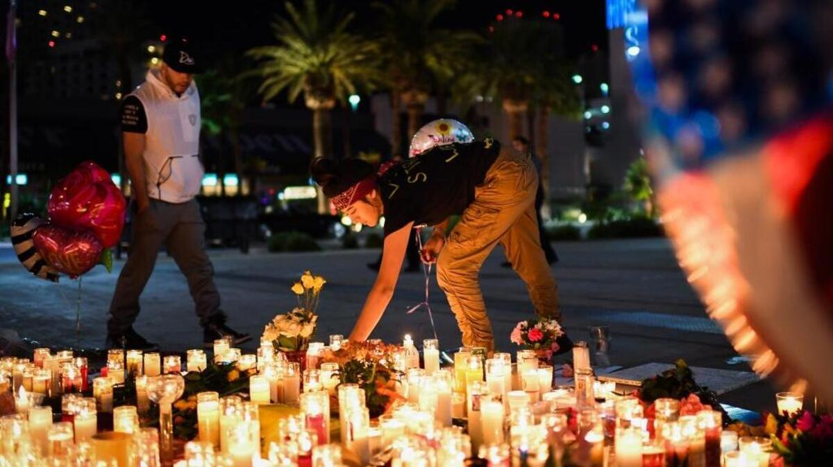 A mourner of the mass shooting lit a candle at a street vigil along the Las Vegas Strip on Monday.