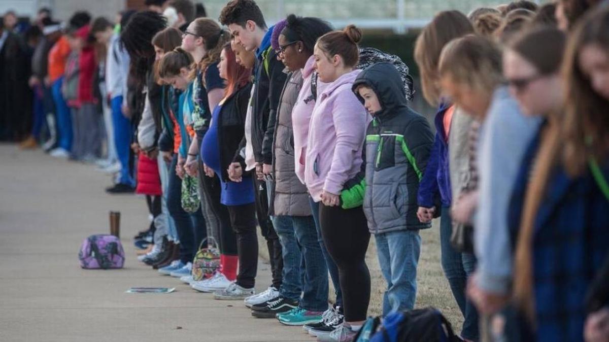 Students and community members hold hands before classes at Paducah Tilghman High School in Paducah Jan. 24, in sympathy with victims of the Marshall County High School shooting the day before.