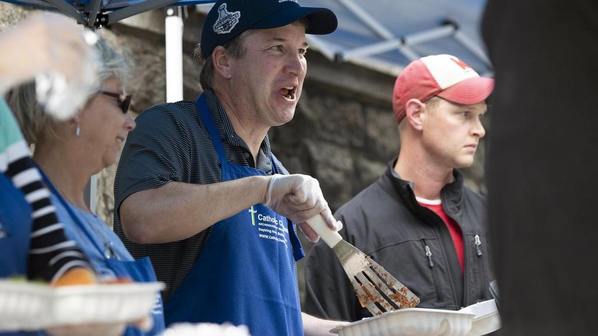 Supreme Court Justice Brett Kavanaugh, center, served meals to the homeless Wednesday while volunteering with Catholic Charities in Washington.