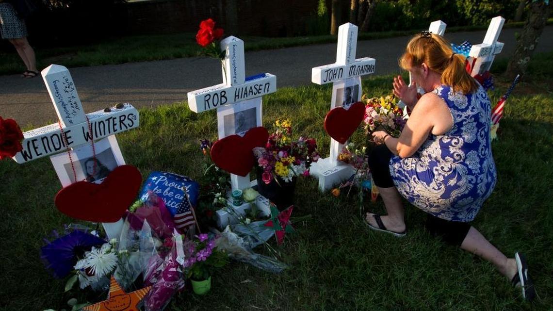 Colleen Joseph prayed over the crosses at a makeshift memorial Sunday for five people killed Thurday inside The Capital Gazette newspaper in Annapolis, Md.