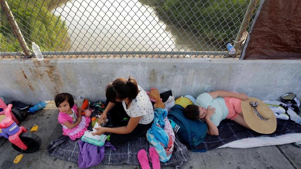 Immigrants from Cuba and Guatemala seeking asylum in the United States wait on the Matamoros International Bridge above the Rio Grande June 29 to leave Mexico for Brownsville, Texas.