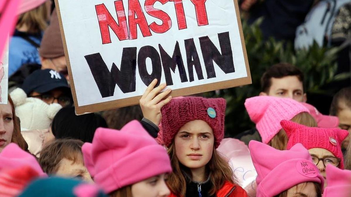 A woman held a sign amidst a sea of pink caps during the January Women’s March on Washington to send a message in support of women’s rights and other causes.
